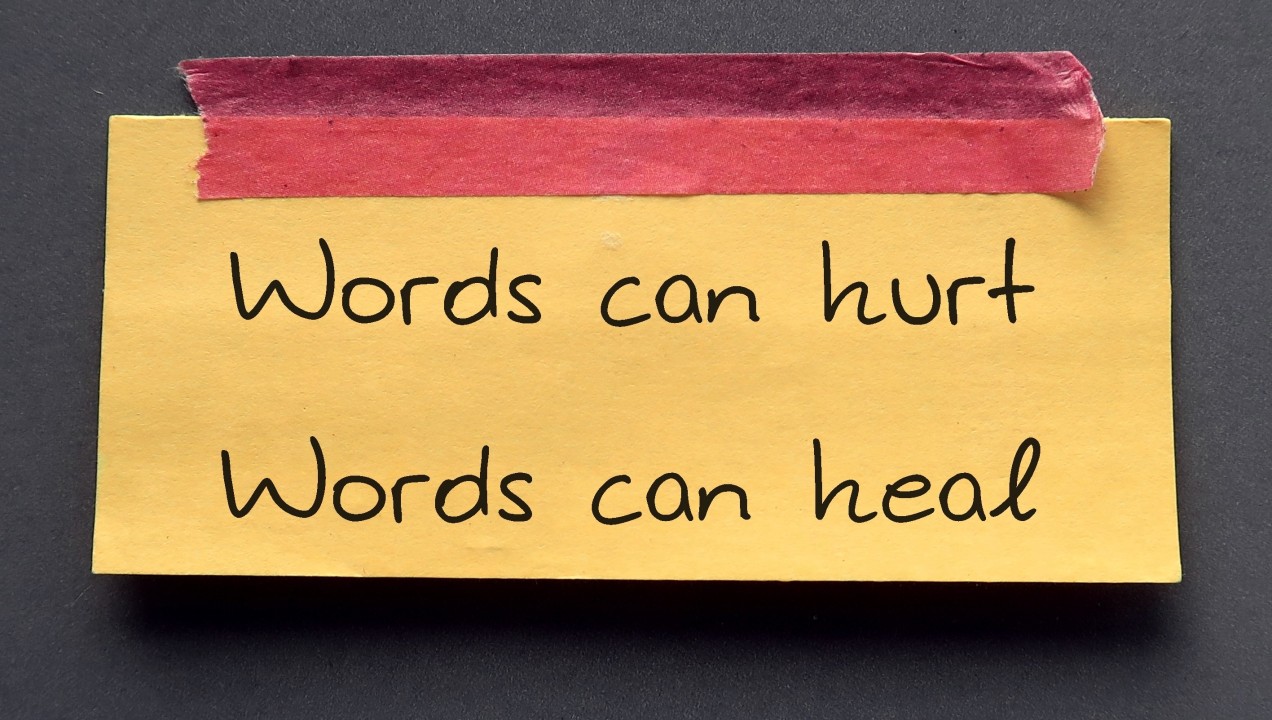 A post-it note with the words "words can hurt you words can heal you".